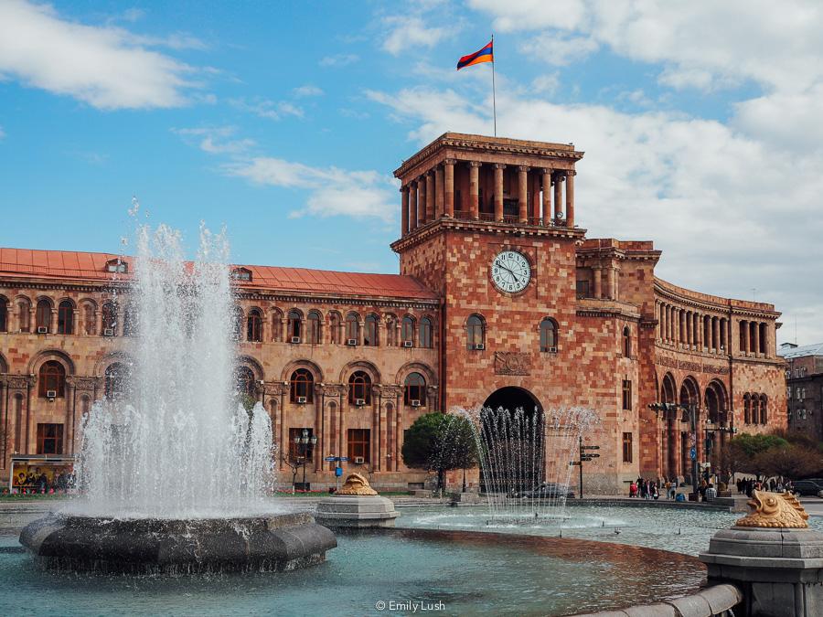 A grand stone building with a fountain in front.