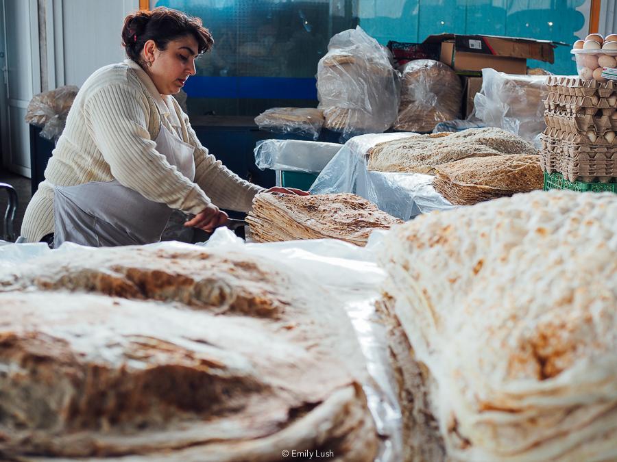 A woman prepares huge sheets of lavash bread at a market in Yerevan, Armenia.