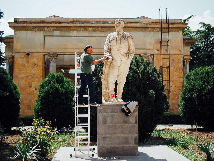 A man cleans a sandstone statue at the Stalin Museum in Gori.