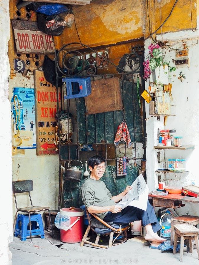 A man reads a newspaper at his shop in the Old Quarter, Hanoi.