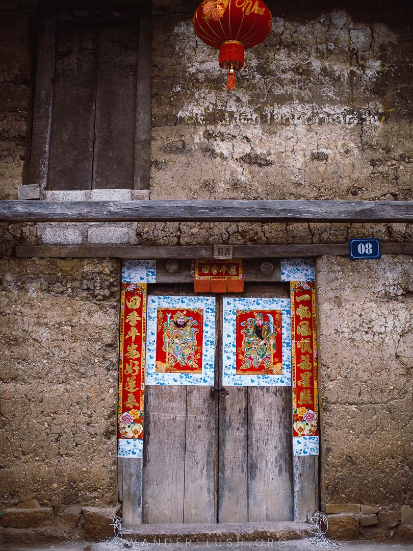 Tet decorations on a wooden doorway in a village in Ha Giang, Vietnam.