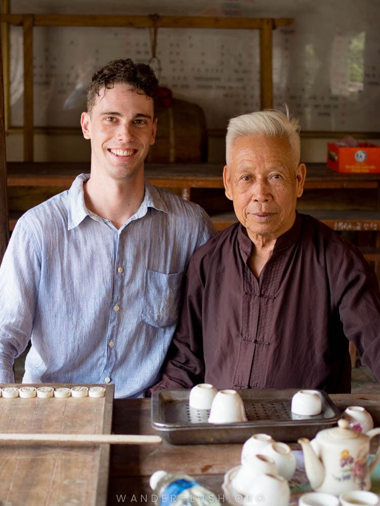 A tourist and an old man at Duong Lam Ancient Village near Hanoi.