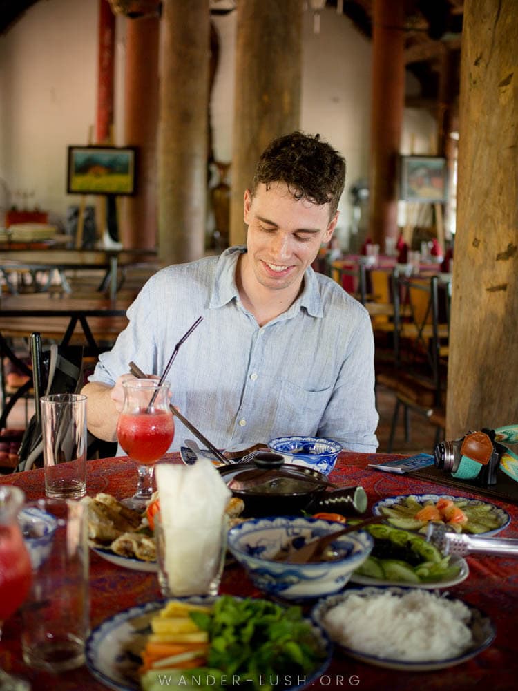 A man eats a spread of Vietnamese food at Moon Garden Homestay in Vietnam.