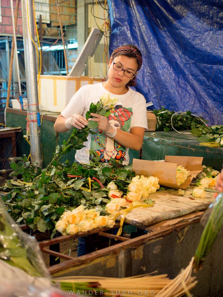 A woman wraps flowers at the Quang Ba Flower Market in Hanoi, Vietnam.