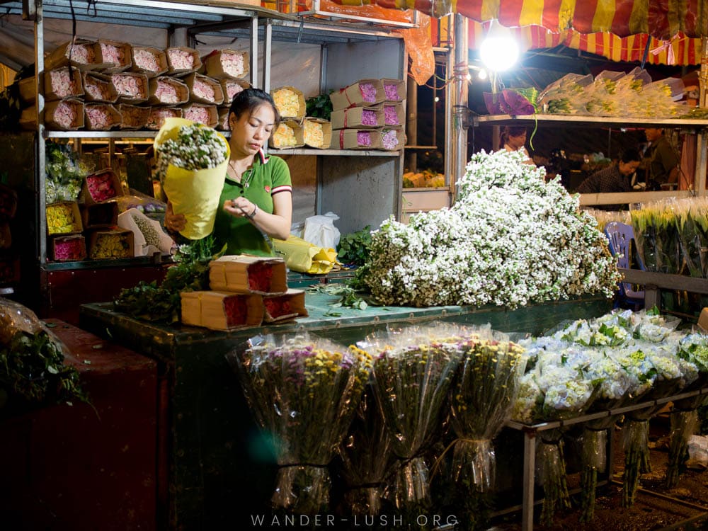 A woman holds a bunch of flowers at her stall at Quang Ba Flower Market in Hanoi.