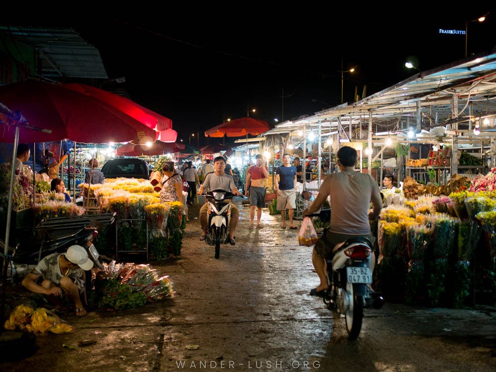 Two men ride their motorbikes through the morning flower market in Vietnam's capital city of Hanoi.
