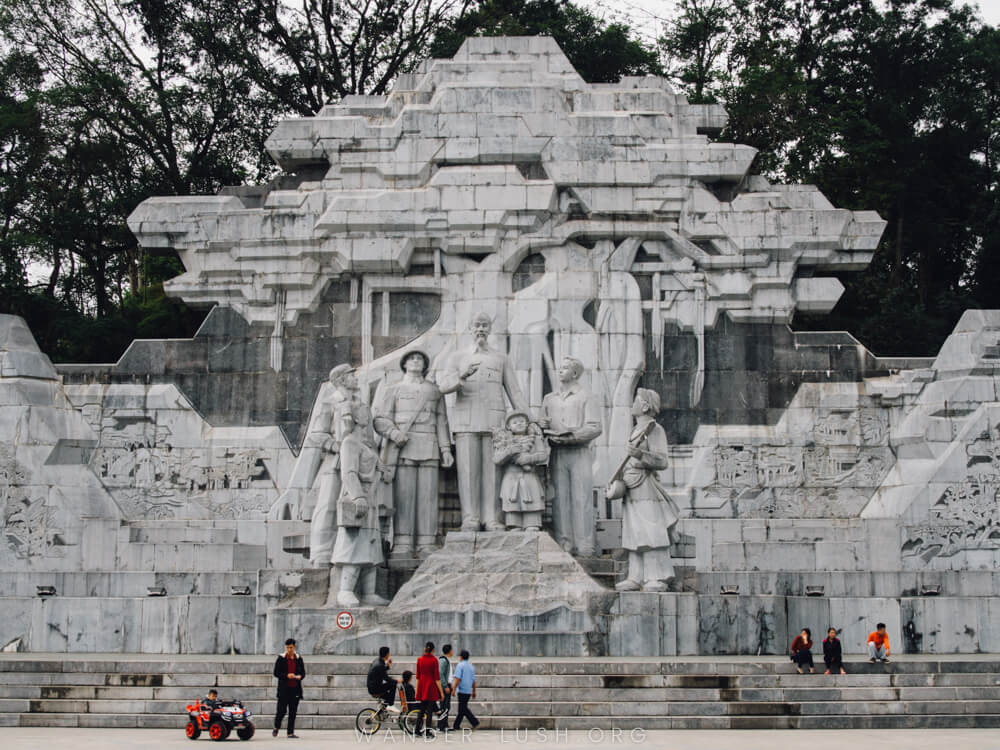 Children play in front of a large concrete monument dedicated to Ho Chi Minh in Tuyen Quang, Vietnam.
