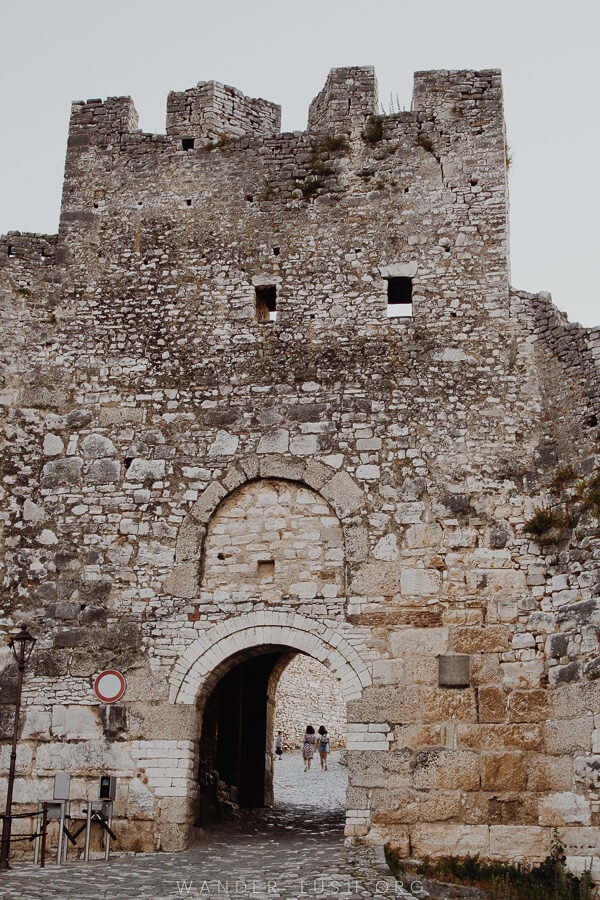 A high stone wall with an entrance portal.
