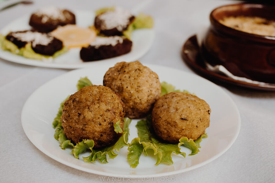 Three plates of local food on a restaurant table.