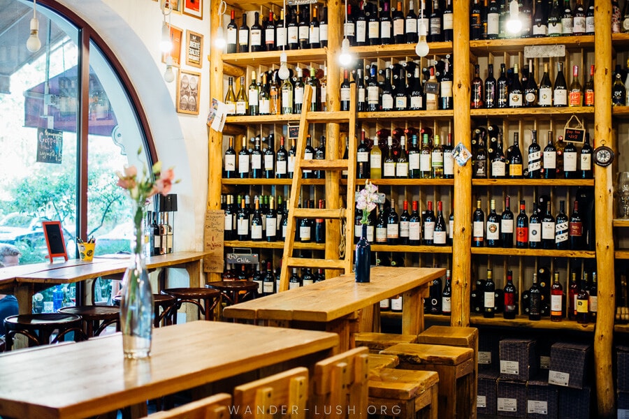 A wine bar in Yerevan, with long wooden tables and racks of bottles on the wall.