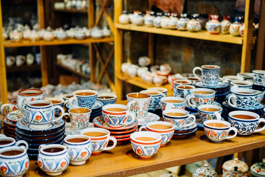 A collection of ceramic cups and plates painted with delicate floral designs at Spitak Ceramics in Yerevan, Armenia.