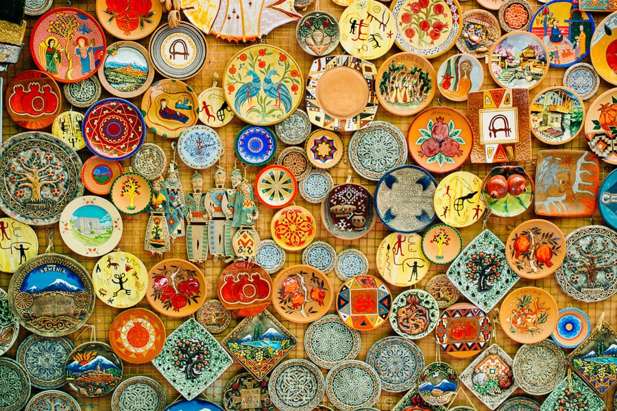 Brightly coloured plates mounted on a wall.