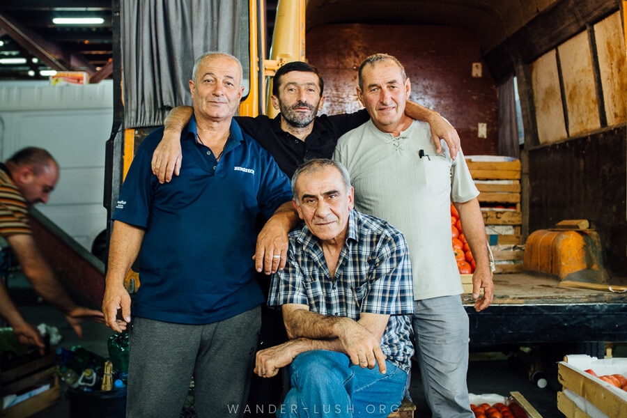 Four men pose for a photo at a market in Tbilisi.