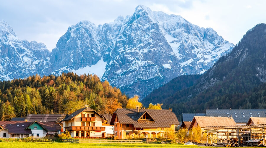 Small houses sit at the foot of the Slovenian Alps.