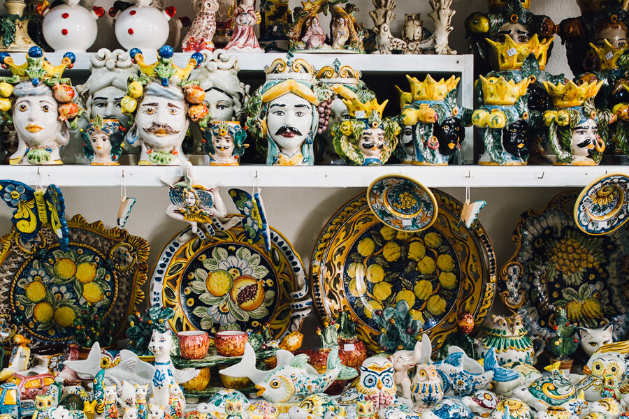 Colourful Sicilian ceramics on a white shelf.