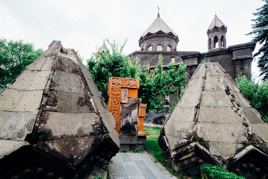 A black church with stone remnants out the front.