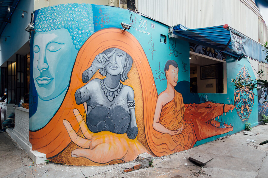 A large wall mural depicting Buddhist symbols in blue and orange paint.