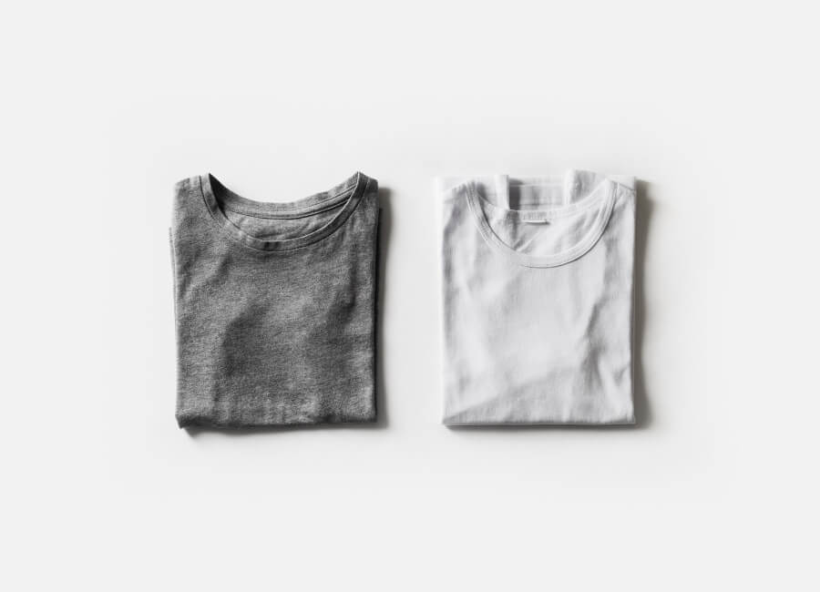 Two folded t-shirts, one grey and one white.
