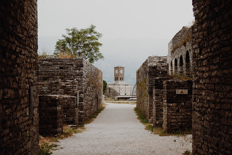 A clocktower visible between stone walls.