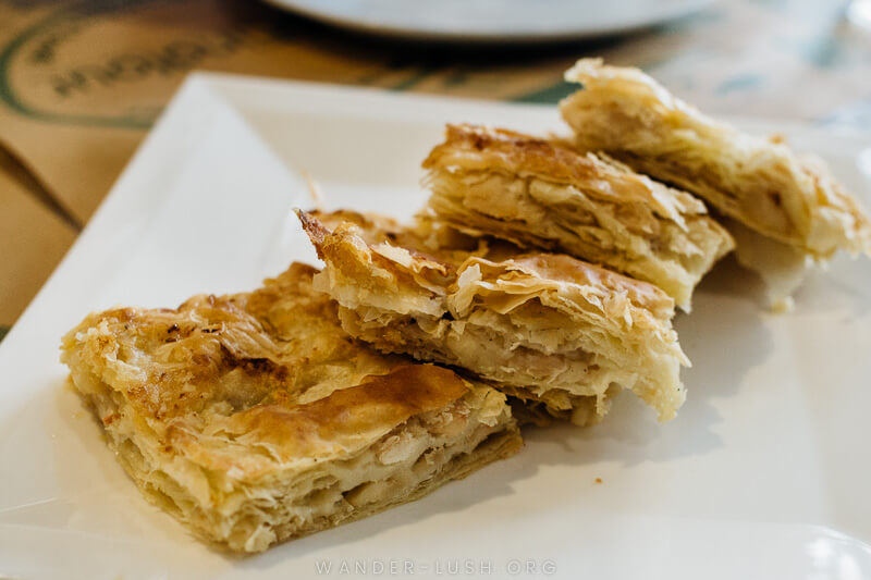 Four pieces of flaky pastry on a white plate.