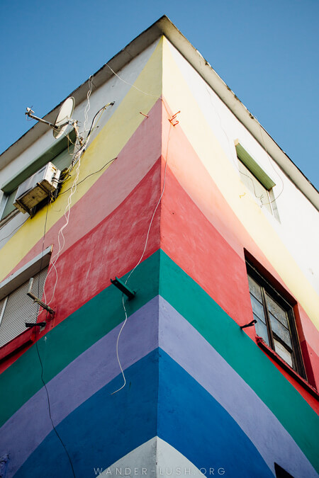 A corner building painted to resemble a rainbow.