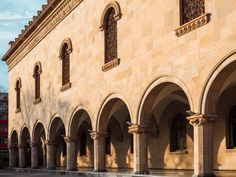 A grand sandstone building with repeating arches in Gori, Georgia.