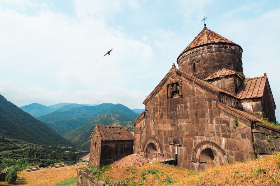 A stone church on a green hill in Armenia.