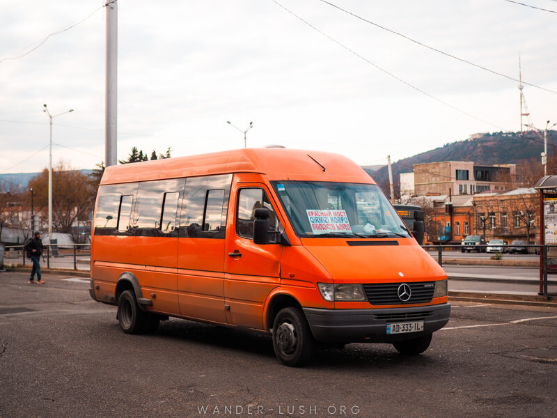 An orange van in a carpark in Tbilisi, Georgia.