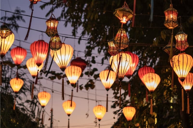 Lanterns hanging above a street at dusk.