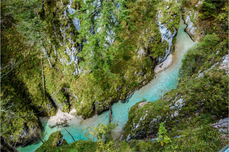 A blue river runs through a gorge in Europe.