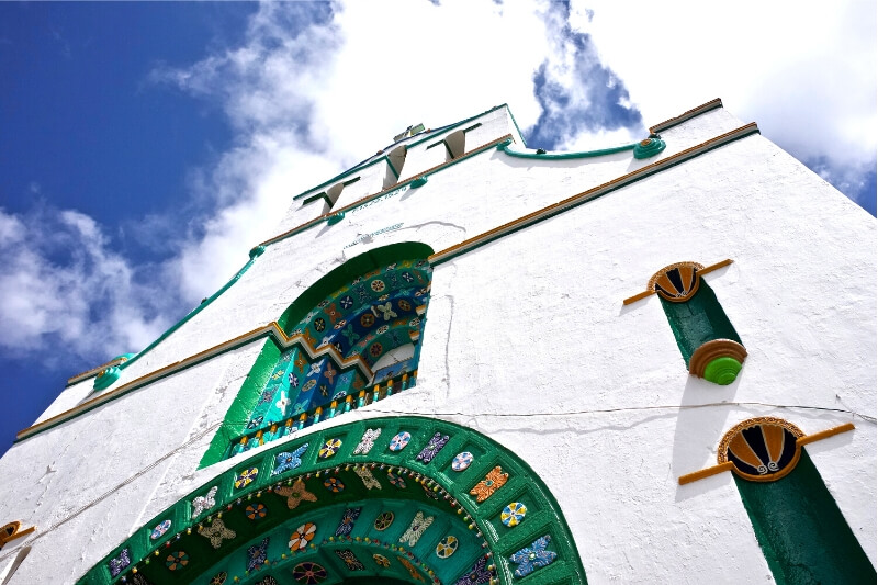 A white church facade with decorative tiling.