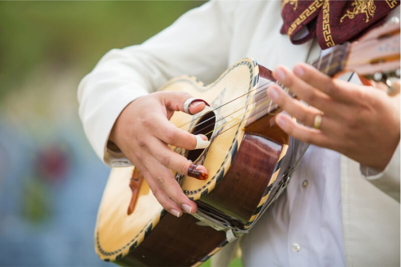 A mariachi singer plays his guitar.