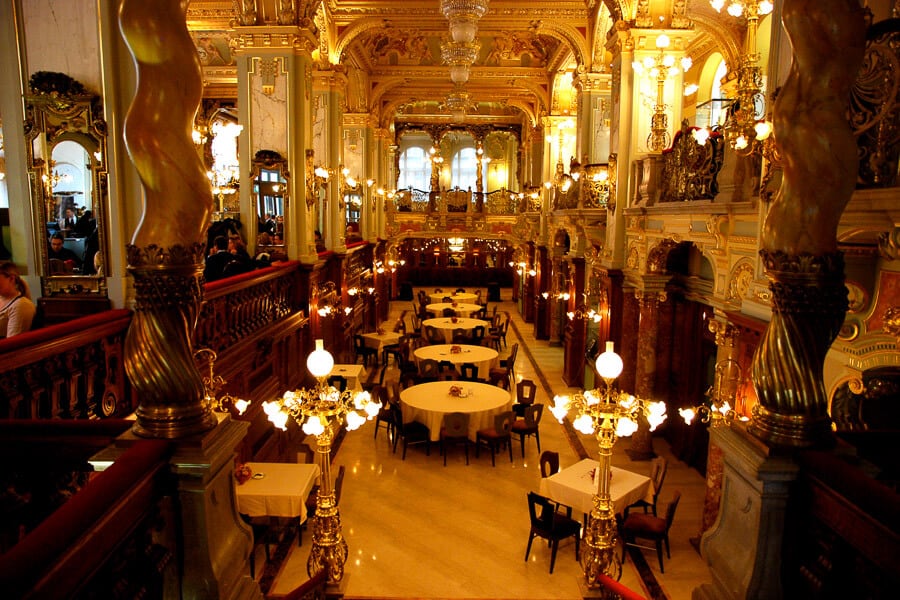 The interior of New York Cafe, lit by chandeliers.