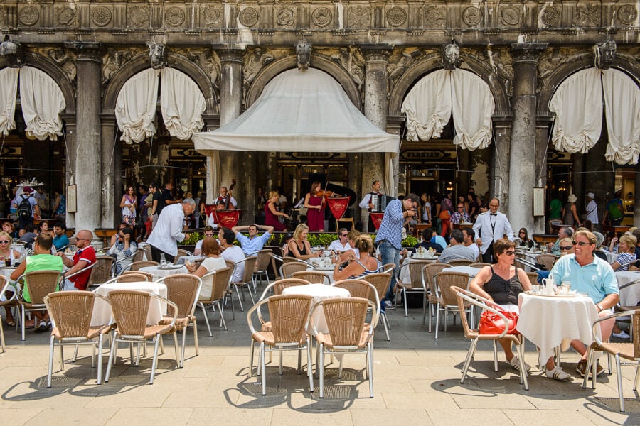 People drink coffee at outdoor tables at Venice's Caffe Florian.