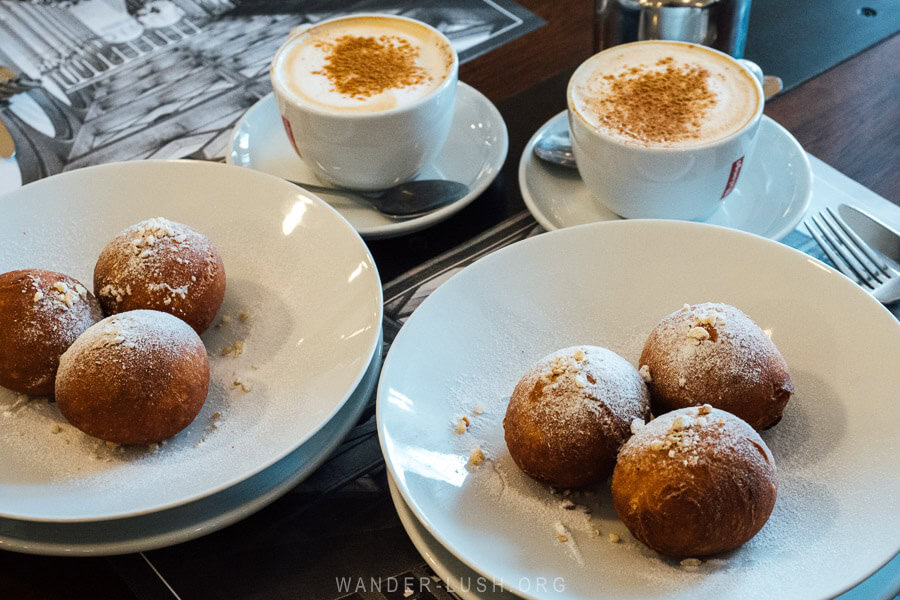 Two plates of round ponchiki donuts at a table at the Tbilisi Cafe Funicular.