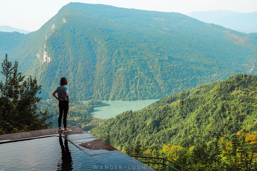 A woman stands on the edge of a pool high in the mountains of Racha – Lailashi Secret Pool.