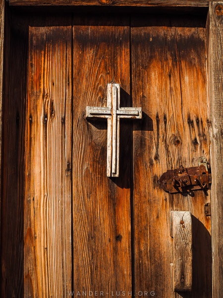 A beautiful wooden door with a white crucifix.