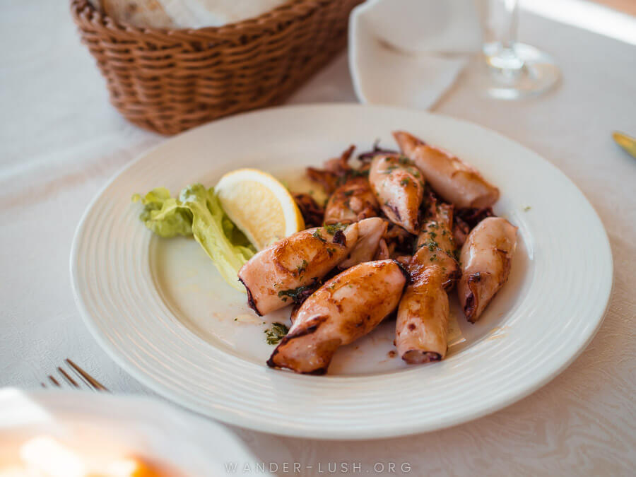 A white plate of fried calamari on a restaurant table.