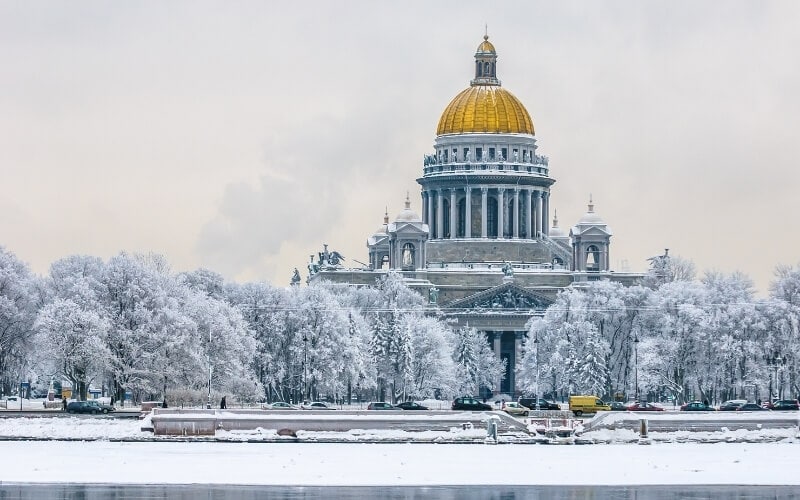 A gold-domed building surrounded by snowy trees in Russia.
