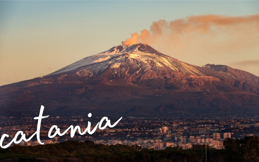 A massive volcano rises above the city of Catania on Sicily.