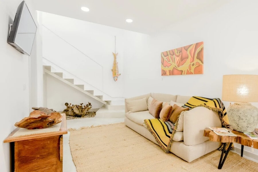 A light-filled apartment in Alcochete with a natural fibre rug on the floor and colourful woven throws on the couch.