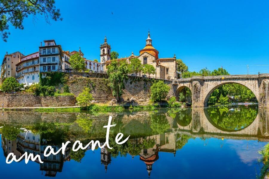 A round stone bridge across the bright-blue river in the beautiful town of Amarante, Portugal.