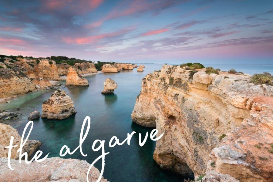 Rock formations under a purple and blue sunset sky on Portugal's Algarve coast.