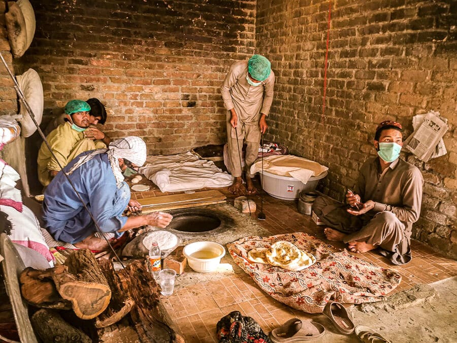 Men sit around a traditional oven and prepare Pakistani bread at the Lok Virsa Heritage Museum in Islamabad.