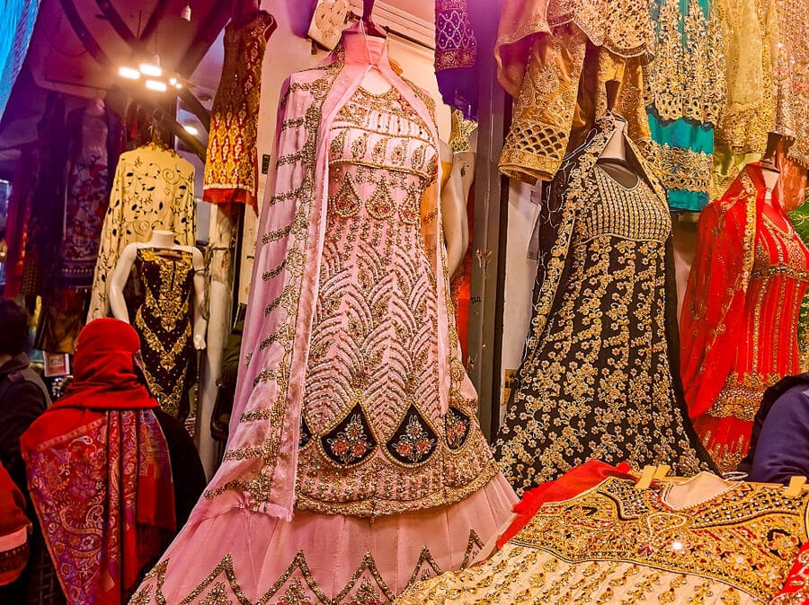 Richly embroidered women's clothing displayed at a local market in Pakistan.