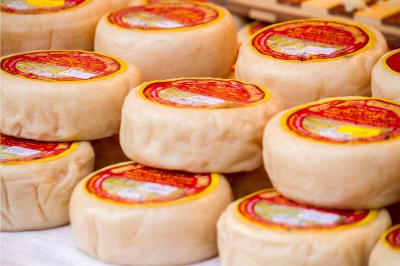 Rounds of Portuguese cheese on display at a souvenir shop in Porto.