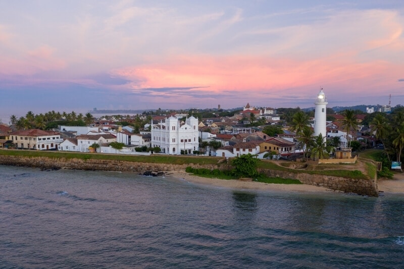 A view of Galle Fort, a coastal settlement in Sri Lanka with a striking white lighthouse.