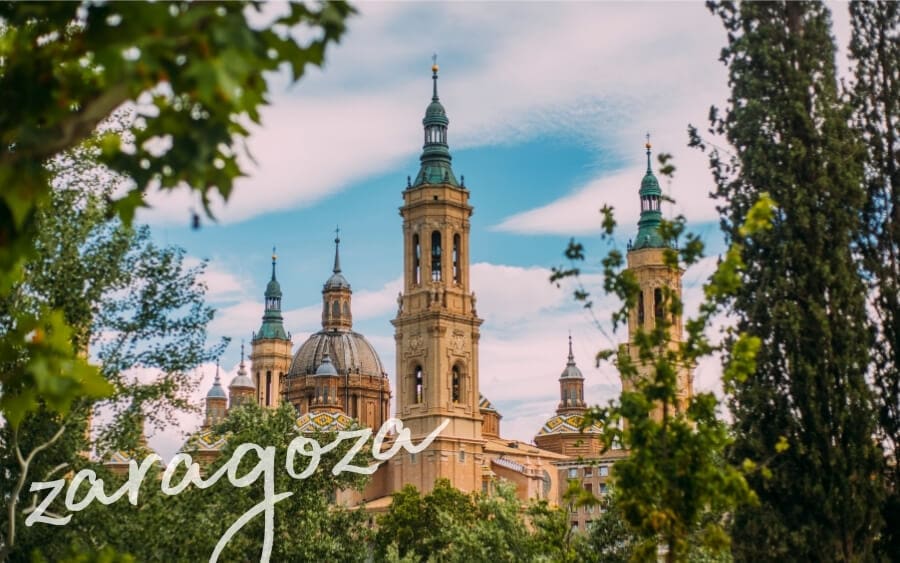 Domes and bell towers rise above a leafy patch of green in the beautiful Spanish city of Zaragoza.