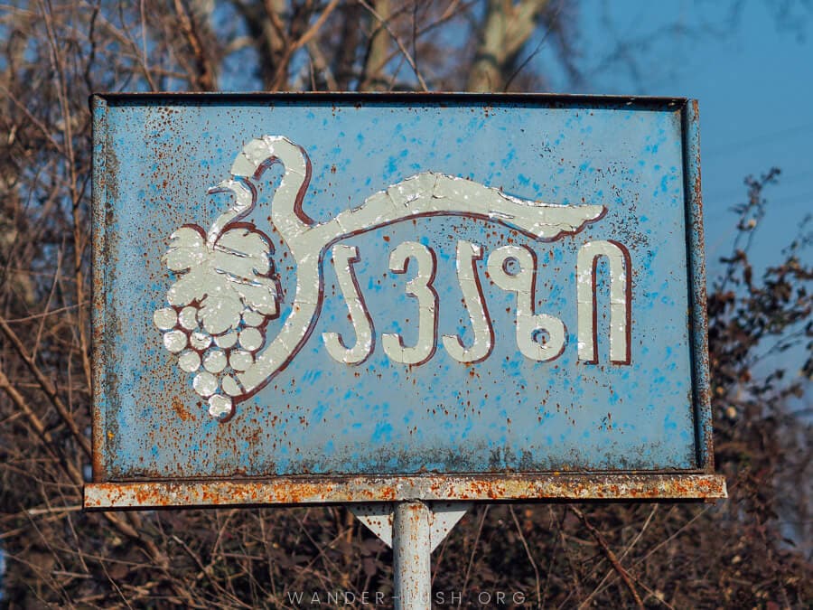 A blue sign with Georgian language script.