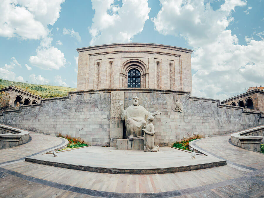 The Matenadaran, an imposing stone building with a statue of two men out front.